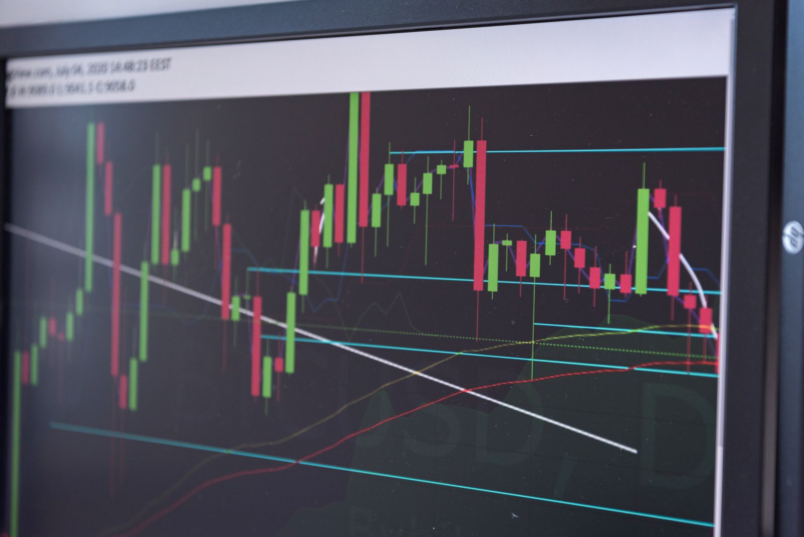 Grafik harga kripto berwarna merah dan hijau di layar monitor